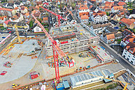 Luftbild Innenstadtbaustelle Übersicht. Mehrere baukräne sind zu sehen. Der Grundriss des neuen Rewe-Marktes ist erkennbar.