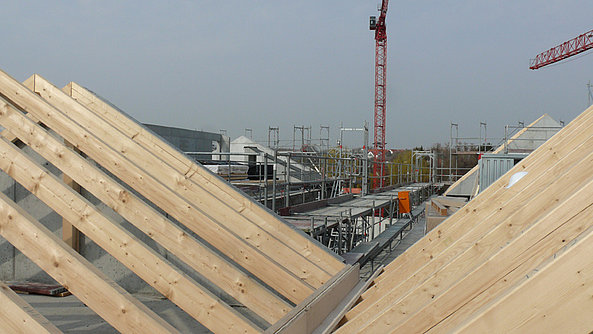 Die Holzbalken des Dach-Rohbaus sind sichtbar.
